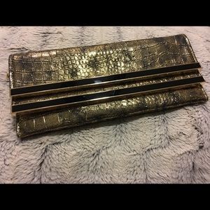 Cache black and gold clutch